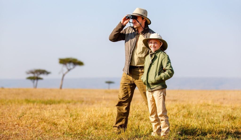 Quels animaux sauvages sont présents en Ouganda ? Un homme et un enfant observe la faune avec des jumelles